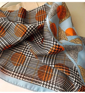 Close-up of silk neckerchief with houndstooth, orange dots and paisley patterns