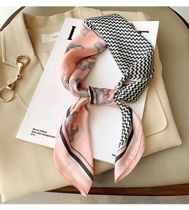 Detail of silk-feel square scarf featuring horse prints and herringbone wave patterns