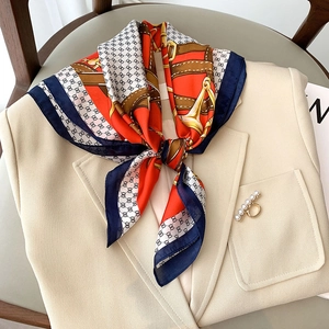 Foulard en soie à motif chaîne équestre bleu marine et orange sur un revers beige