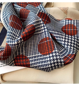 Detailed close-up of navy houndstooth silk scarf with large red polka dot pattern