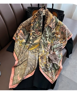 Detail of a large satin square scarf with leopard print and tropical floral patterns