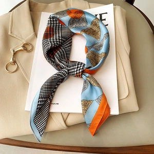 Fashionable square silk scarf with houndstooth and paisley print on a beige blazer