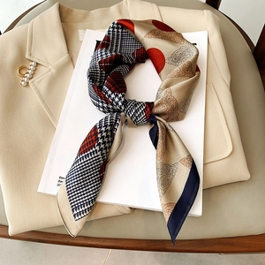 Elegant silk-like square scarf with houndstooth and polka dot patterns on a beige blazer