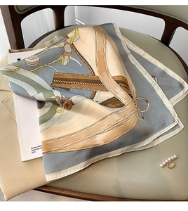 Detailed pattern of silk scarf with equestrian belt print and pearl ring accessory