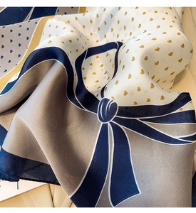 Detailopname van zijden sjaal met gouden hartjes en blauwe strikpatronen texturen