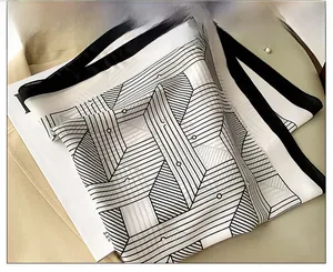 Close-up of black and white geometric pattern silk scarf with modern polka dot design