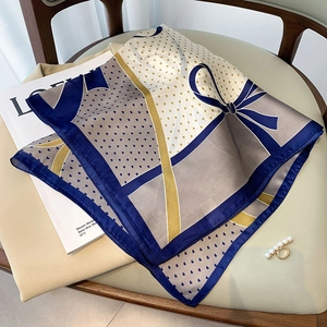 Elegante zijden sjaal met blauwe vlinderpatronen op een zachte vintage stoel