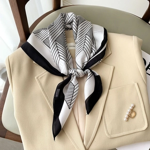 Elegant geometric line silk square scarf with pearl buckle on beige blazer collar