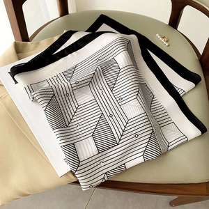 Elegant black and white geometric silk scarf with contrast border and pearl ring detail