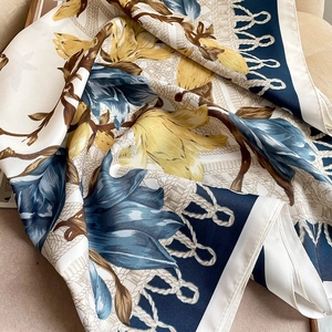 Detail of floral printed scarf showing large yellow and blue flowers with rope patterns