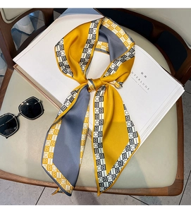 Detail of silk-like neck scarf with letter print and color-block design on magazine