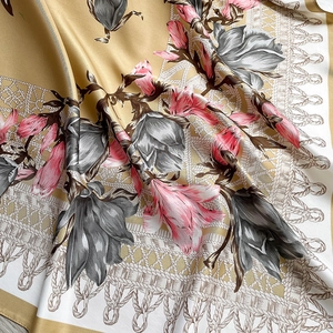 Detail of silk-like scarf with floral magnolia print and elegant rope pattern texture