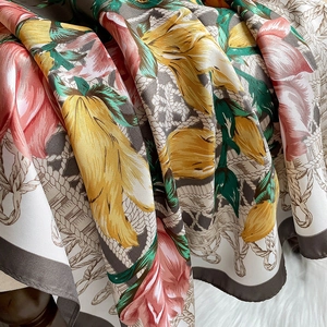 Detailed view of floral silk scarf with pink roses and elegant contrast border