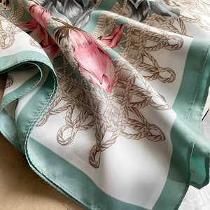 Detail of silk scarf showing floral patterns and fine hem stitching in mint green