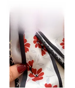 Détail d'un foulard en simili soie de haute qualité avec motif floral et texture lisse