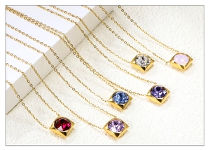 Detail of square gold pendants featuring vibrant multi-colored cubic zirconia birthstones