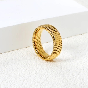 Minimalist golden stainless steel ring with Tubogas texture on geometric display
