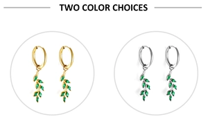 Detail of leaf dangle earrings with green marquise stones in gold and silver finishes