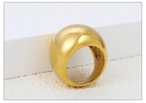 Détail d'une bague bombée plaquée or 18 carats sur des supports blancs modernes