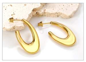 Vue détaillée de boucles d'oreilles en U dorées avec une finition métallique polie