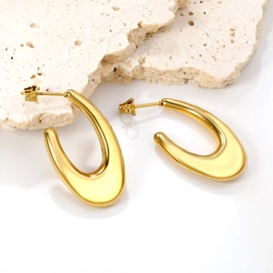 Boucles d'oreilles dorées polies en forme de U pour femmes sur fond de pierre minimaliste