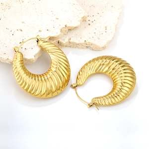 Boucles d'oreilles créoles croissant dorées avec texture nervurée sur socle en pierre
