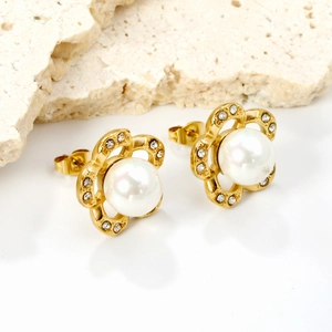 Elegant gold flower pearl earrings with sparkling rhinestones on polished marble surface