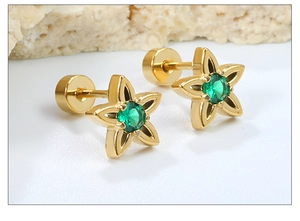 Macro shot of gold star stud earrings with green zircon and flat screw back design