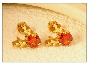 Vue détaillée de boucles d'oreilles rennes dorées avec pierre de zircon rouge