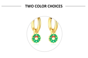 Détail de boucles d'oreilles créoles dorées avec couronnes de Noël en émail vert et nœuds