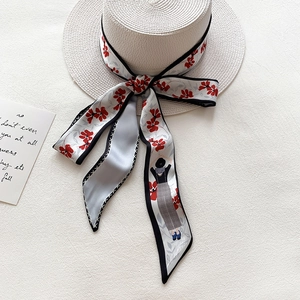 Chapeau de paille à sommet plat avec ruban à fleurs sur un fond en lin texturé blanc