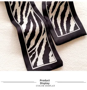 Macro detail of zebra print silk scarf showing smooth satin texture and black white pattern