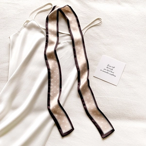Gros plan du foulard en soie à pois beige sur satin avec une texture de qualité