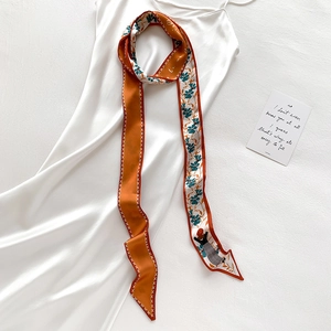 Foulard twilly en soie à imprimé fleuri et contraste orange sur robe en soie blanche