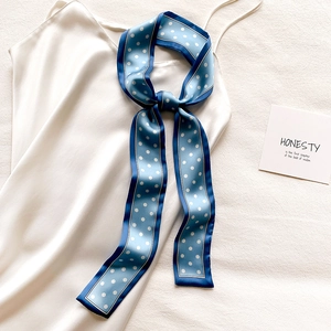 Petit foulard en soie à pois noué sur un débardeur en satin blanc comme accessoire