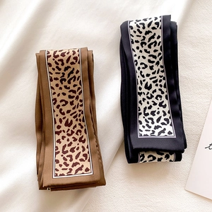 Detail of leopard print narrow scarves in brown and monochrome tones on soft fabric