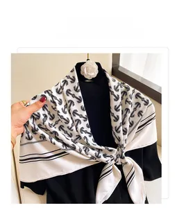 Detail of white square silk scarf with black anchor print and striped edges