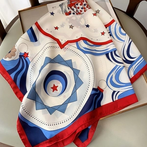 Close-up of red and blue star pattern silk scarf folded on a chair showing fabric texture