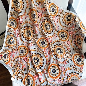Detailed view of large floral print shawl with mandala patterns and fine edge stitching