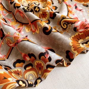Close-up of retro floral print silk scarf with satin finish and soft elegant draping