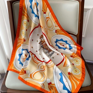 Detailed close-up of equestrian silk scarf with orange border and horse pattern