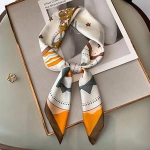 Artistic geometric print silk scarf with star motifs on cream background in tray