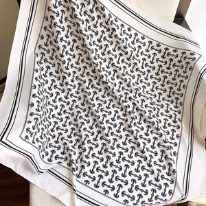 Detailed view of white and black silk scarf with anchor chain pattern on fabric seat