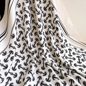 Detailed view of nautical anchor and chain print on silky beige elegant square scarf