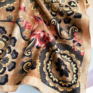 Detail of vintage floral pattern on soft twill silk scarf with warm brown tones