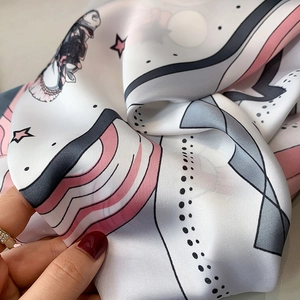 Detailed view of soft printed silk scarf texture with pink waves and starry patterns