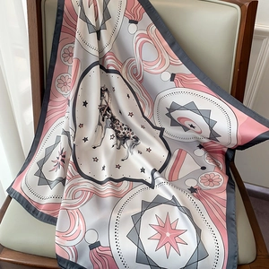 Detail of silk-textured scarf with carousel print draped over a wooden chair