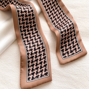 Detail of classic houndstooth silk scarf showing premium satin texture and coffee tones