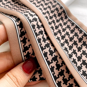 Close-up of houndstooth leopard pattern silk scarf showing soft texture and premium luster