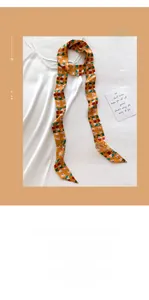 Close-up of a French style orange silk scarf with cat and geometric patterns for hair or bags